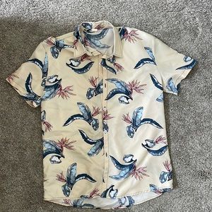 Beige button down shirt with bird of paradise flower